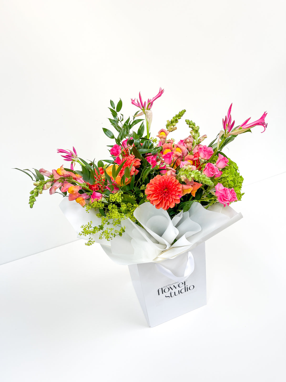 Bouquet of colorful flowers in a white box with 'Flower Studio' branding on a white background