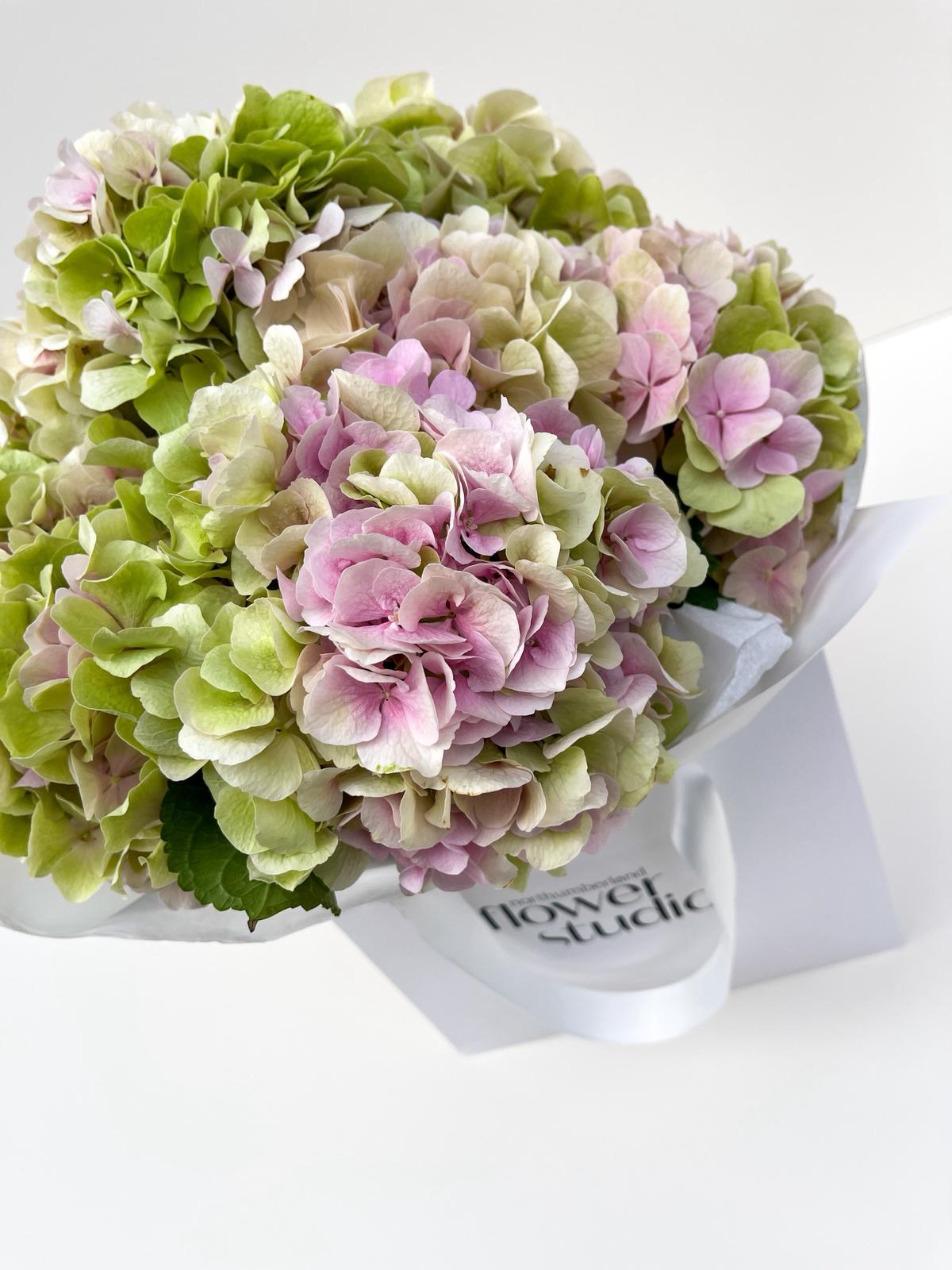 Bouquet of pink and green flowers with 'Flower Studio' branding on a white background