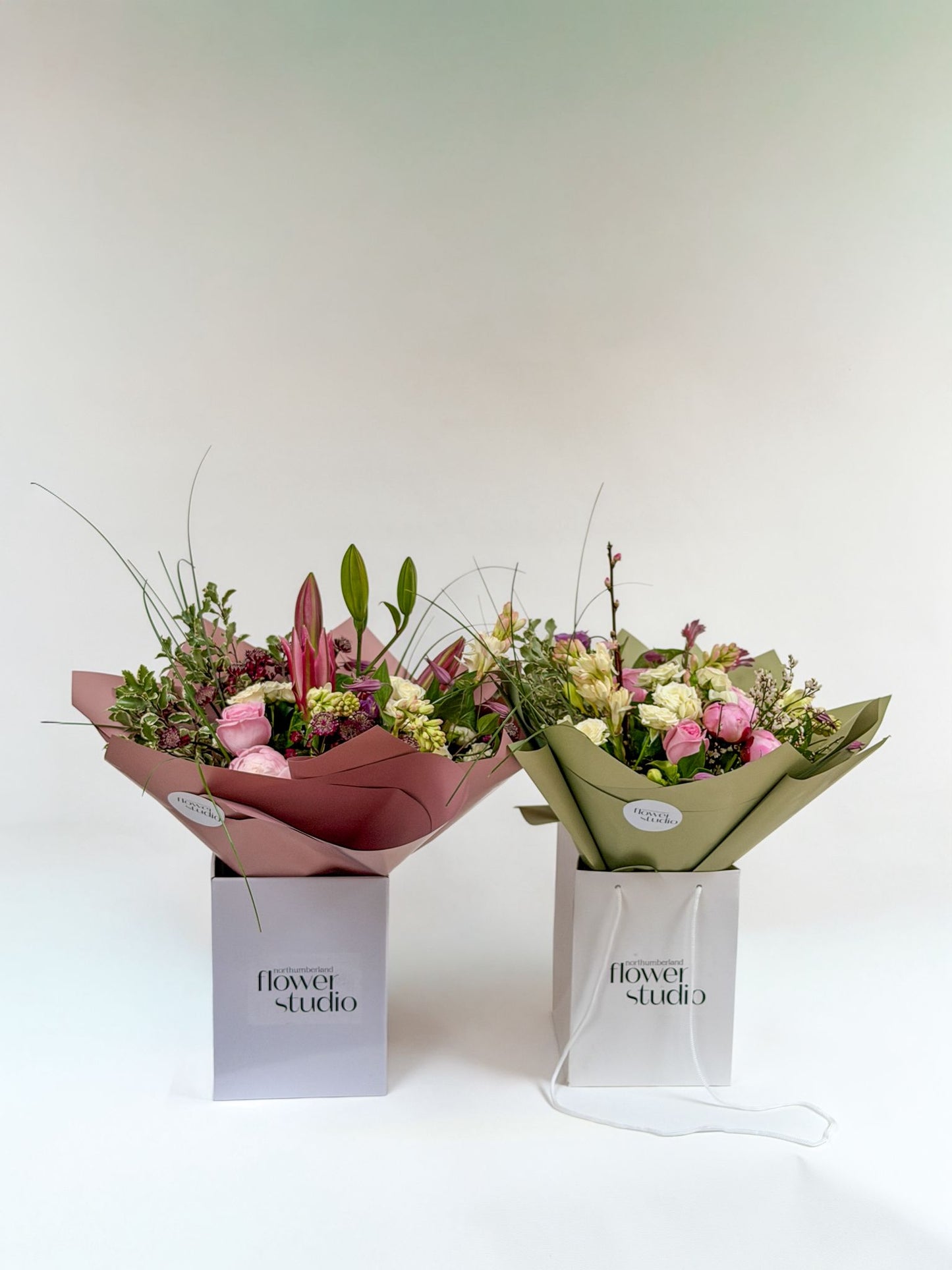 Two flower bouquets in luxury wraps with 'Northumberland Flower Studio' branding on a white background