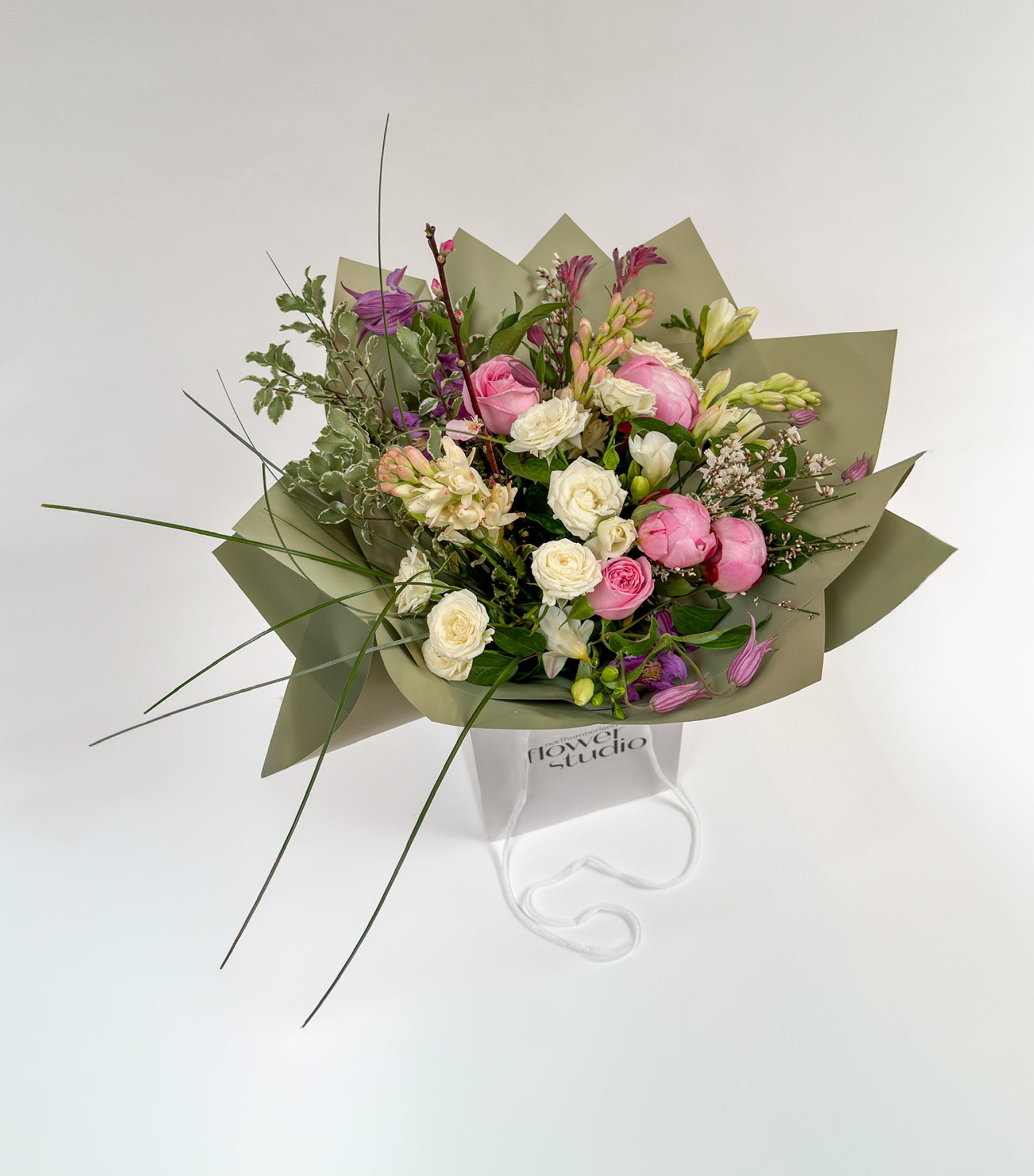 Bouquet of Mother’s Day flowers with green wrap on a white background