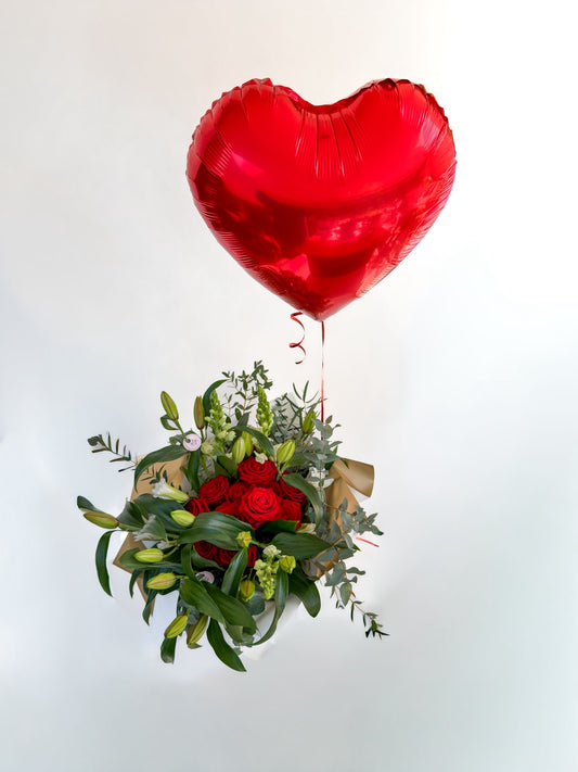 Red heart-shaped balloon tied to a bouquet of flowers on a white background