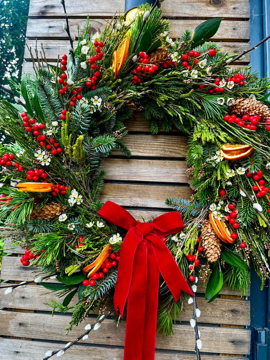 Christmas wreath with red bow on a wooden door