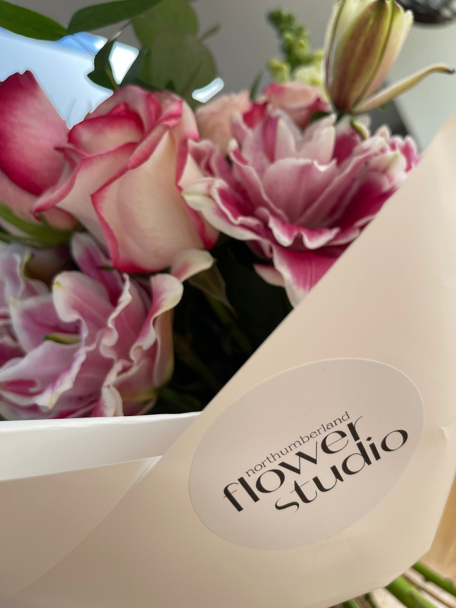 Bouquet of pink and white flowers with a 'Northumberland Flower Studio' box in the foreground.