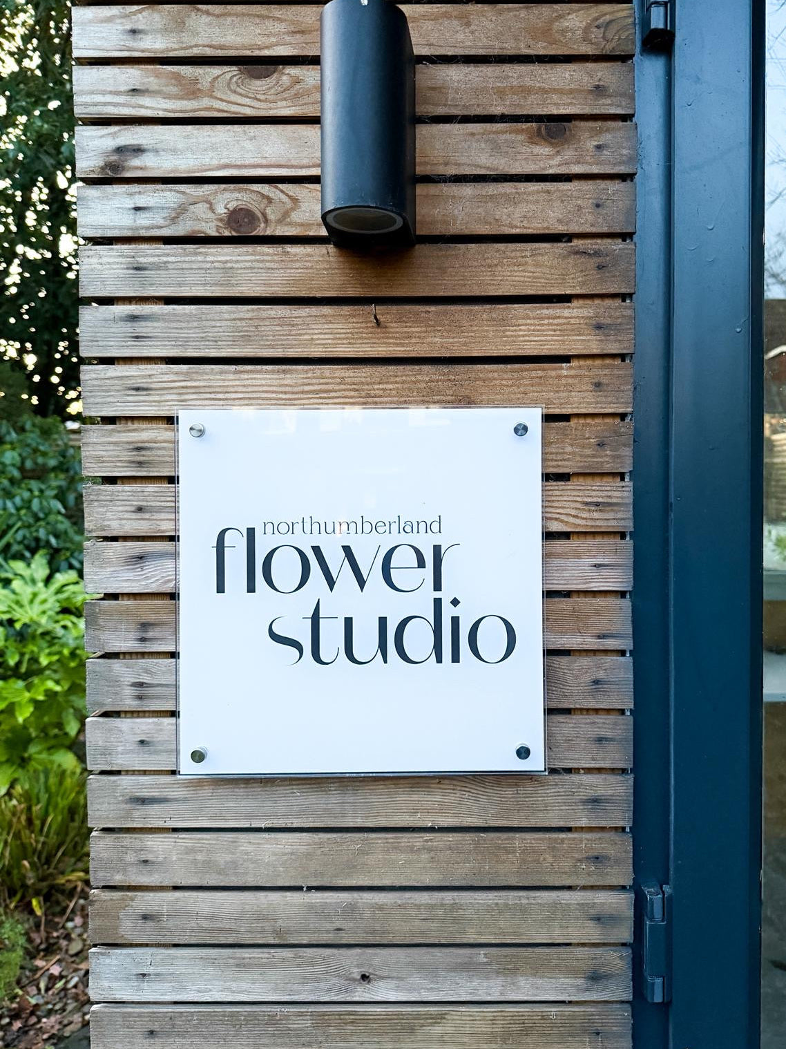 Wooden wall with a sign reading 'northumberland flower studio'